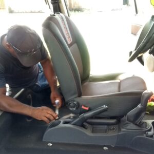 Profissional desmontando o banco do carro para realizar higienização de bancos de carro para remoção de manchas e ácaros.